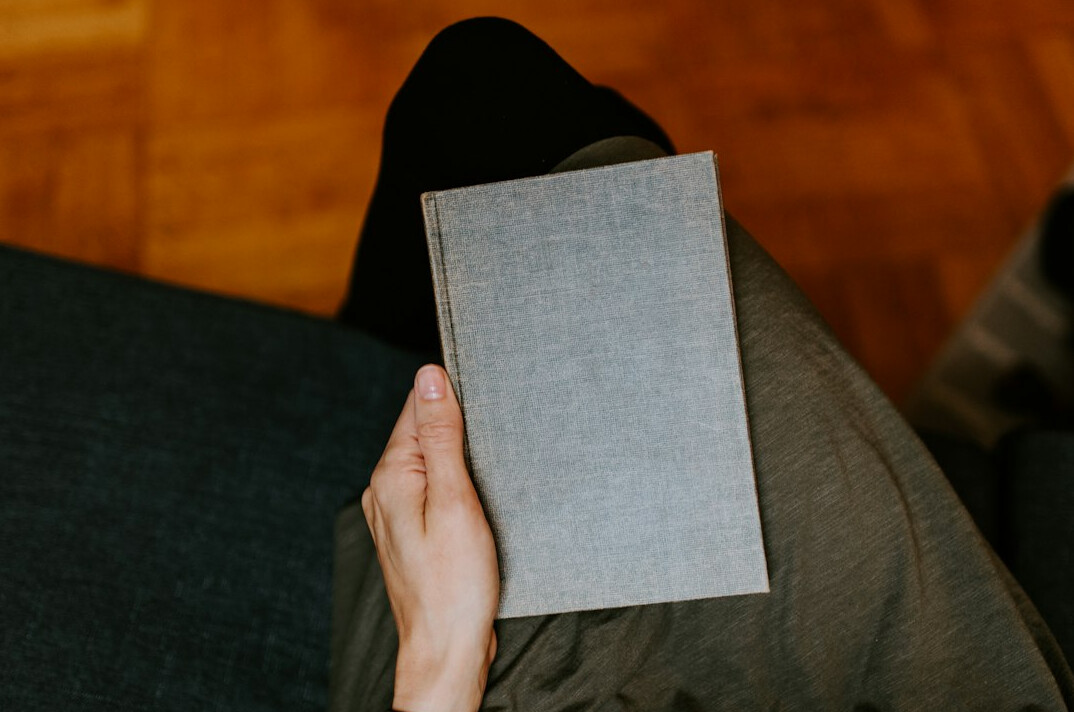 person reading mystery book at home
